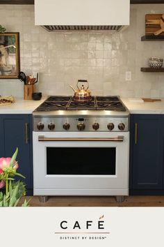 a white stove top oven sitting inside of a kitchen next to blue cabinets and counter tops