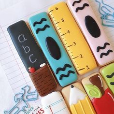 there are many decorated cookies in the shape of pencils and rulers on top of each other