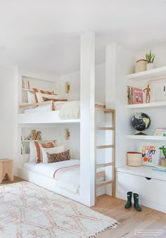 a white bedroom with bunk beds and bookshelves