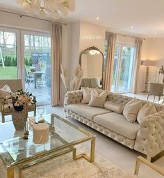 a living room filled with lots of furniture next to a large glass table in front of a window