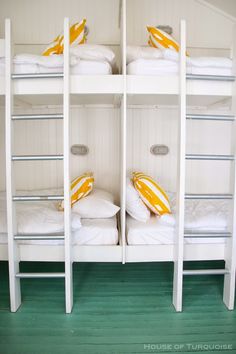 bunk beds with yellow and white pillows on them