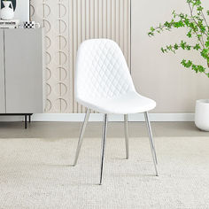 a white chair sitting on top of a rug next to a potted green plant