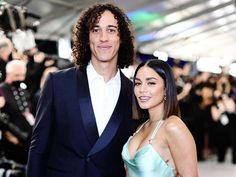 a man and woman standing next to each other on a red carpet at an event