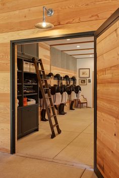 the inside of a horse stable with wooden walls and ladder leading up to it's stalls