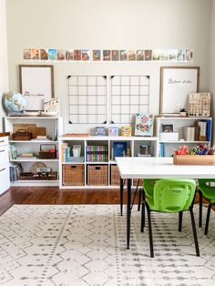 a room filled with lots of books and toys on top of white shelving units