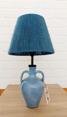 a blue vase with a lamp on top of it