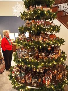 a christmas tree is decorated with gingerbreads and other holiday decorations as people look on