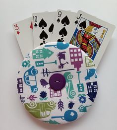 four playing cards are sitting next to each other on top of a white surface,