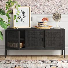 the sideboard is next to a plant and pictures