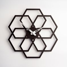 a clock made out of black metal on a white surface with geometric shapes and numbers