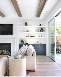 a living room filled with furniture and a flat screen tv mounted on the wall above a fire place