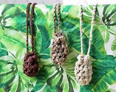 three crocheted necklaces hanging on a green and white background with palm leaves