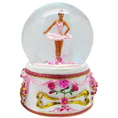 a snow globe with a ballerina figure in it's center and pink roses on the bottom