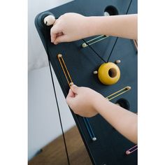 two children are playing with toys on the play table in their room, one child is trying to put them together