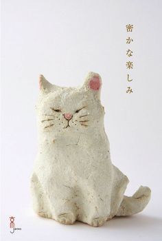 a white cat figurine with chinese writing on it