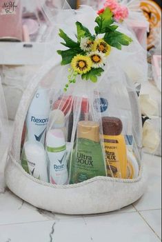 a white bag filled with lots of different types of beauty products and flowers on top of a counter