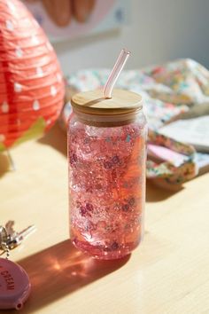 a jar filled with pink liquid sitting on top of a table next to a pair of keys