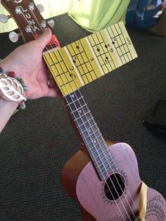 someone is holding a small wooden ukulele in their hand