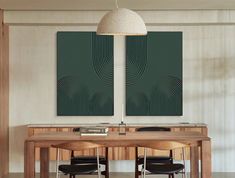 two paintings on the wall above a wooden table