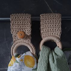 two crocheted baskets with wooden handles are next to each other