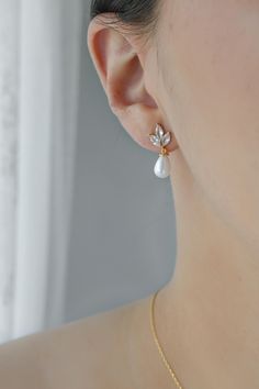 By using our favourite marquise crystals to make up this simple, yet classic design, we present the Aria Pearl Earrings. The Aria features a 3 marquise crystal pattern finished with a long, hanging white pearl. This charming earring is perfect for that effortless minimal and modern clean look.  Pair with Kiki Backdrop Necklace OR Yara Backdrop Necklace Earring Length: 20 mm / Width: 10 mm MATERIALS: Cubic Zirconia, Synthetic Pearls Gold, Rose Gold, or Rhodium Plated Brass 92.5 Sterling Silver Po Elegant Marquise Teardrop Earrings For Wedding, Marquise Pearl Drop Jewelry For Weddings, Elegant Marquise Bridal Earrings For Wedding, White Marquise Earrings For Wedding, Marquise Cut Bridal Earrings For Wedding, White Marquise Wedding Earrings, Gold Marquise Cut Wedding Earrings, Elegant Marquise Cut Earrings For Wedding, Elegant Marquise Cut Wedding Earrings