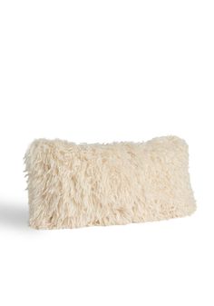 a white furry pillow sitting on top of a table