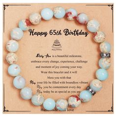 a happy 65th birthday card with a bracelet made out of blue and white beads