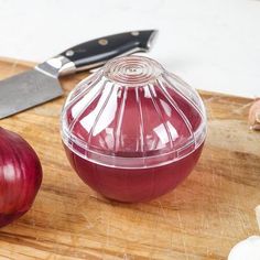 an onion on a cutting board next to a knife