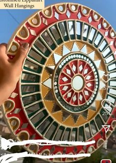 a person holding up a circular object with many different colors and designs on it,