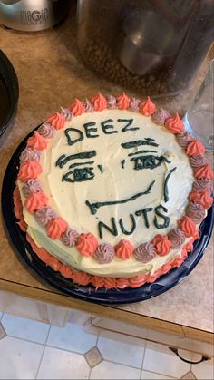 a cake with frosting that says deez nuts on it sitting on a counter