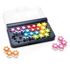 an assortment of colorful stars in a plastic tray on a white surface next to each other