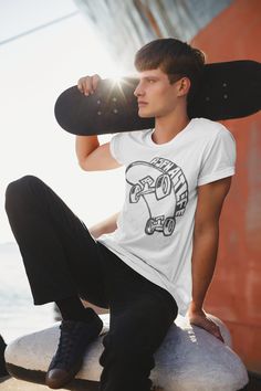 a young man sitting on top of a rock holding a skateboard over his head