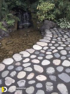 a stone path leading to a small waterfall