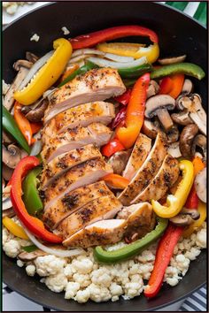 chicken, peppers, and cauliflower in a skillet on top of rice