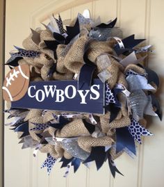 a football wreath with the word cowboys on it is hanging from a front door,