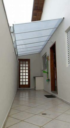 an empty room with tiled floors and white walls, has a skylight above the door