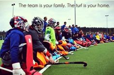 a group of people sitting on top of a field next to each other wearing helmets