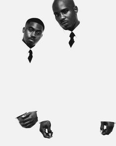 two black men in suits and ties pointing their fingers at the camera with one hand