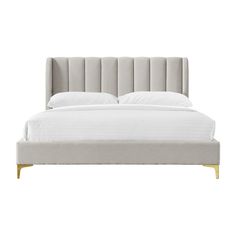 an upholstered bed with white linens and gold legs on a white background