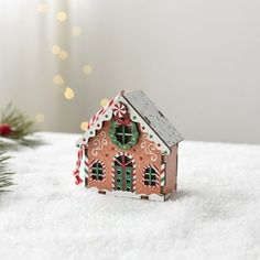 a small gingerbread house on top of snow