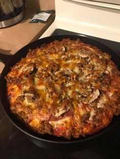 a pizza sitting on top of a stove next to an oven