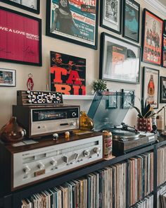 a record player sitting on top of a shelf next to a wall full of records