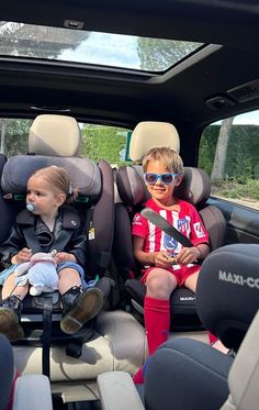 two children sitting in the back of a car seat