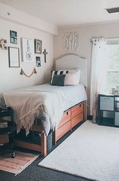 a bedroom with a bed, dressers and pictures hanging on the wall above it