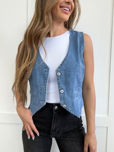 Don't let fall fashion get you in a tizzy, keep it simple with our Dacia Button Up V-Neck Sleeveless Denim Top. This versatile vest features functional buttons and a flattering v-neck neckline, making it the perfect addition to any outfit. And with its soft and comfortable material, you'll want to wear it all season long. DETAILS Will ship within 3 weeks Sleeveless denim vest Functional buttons V-neck neckline Denim vest Versatile styling Soft, comfortable material Perfect for the fall season SI How To Style Denim Vest, Jean Vest Outfits Fall, Denim Vest Outfits For Women, Denim Vest Outfit Summer, Denim Vest Outfit Fall, Blue Vest Outfit, Fall Vest Outfits, Jean Vest Outfits, Sleeveless Denim Vest