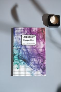 a book with the title graph paper composition on it next to a small light bulb