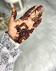 a woman's hand with henna tattoos on it