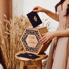 a woman is placing a card into a wooden box