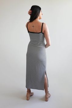 a woman in a black and white striped dress with her back turned to the camera