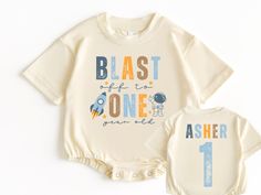 two baby onesuits with the words blast life to one and an astronaut on them